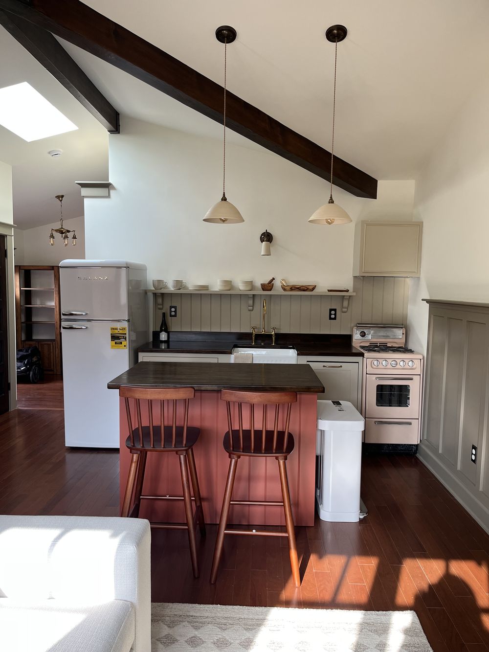 Craftsman ADU kitchen with coral island, retro range, exposed beam and skylight